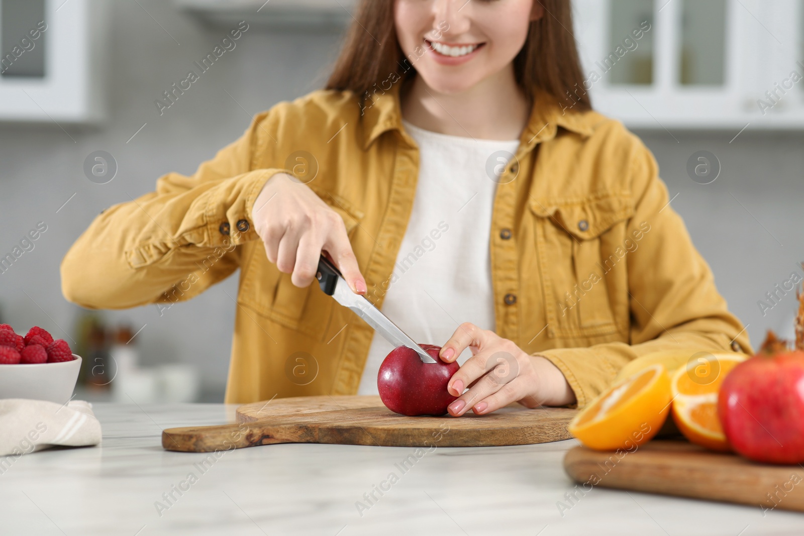 Photo of Woman preparing ingredients for tasty smoothie at white marble table in kitchen, closeup