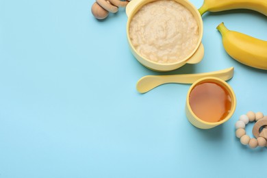 Photo of Healthy baby food in bowl and accessories on light blue background, flat lay. Space for text