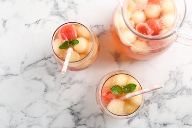 Melon and watermelon ball cocktail with mint served on white marble table, flat lay