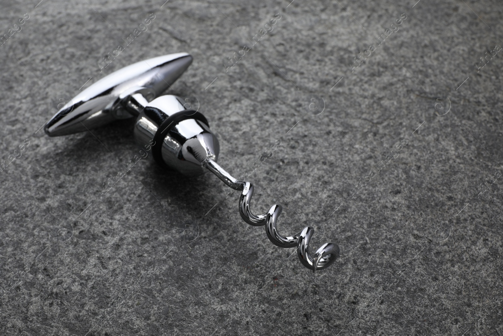 Photo of One metal corkscrew on grey textured table