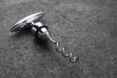 One metal corkscrew on grey textured table