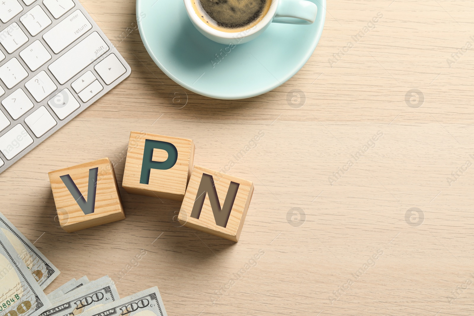 Image of Cubes with acronym VPN, cup of coffee, money and keyboard on wooden background, flat lay. Space for text