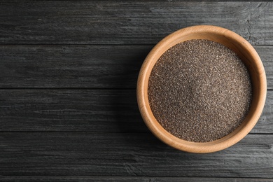 Photo of Bowl with chia seeds on wooden background, top view. Space for text