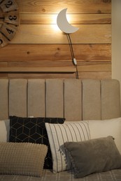 Crescent shaped night lamp on wooden wall in room
