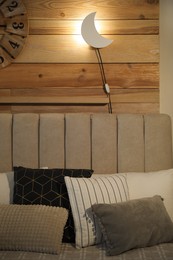 Photo of Crescent shaped night lamp on wooden wall in room