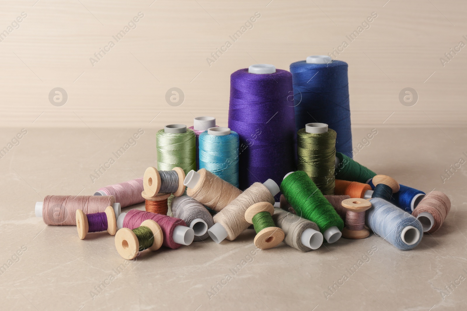 Photo of Set of color sewing threads on light grey table