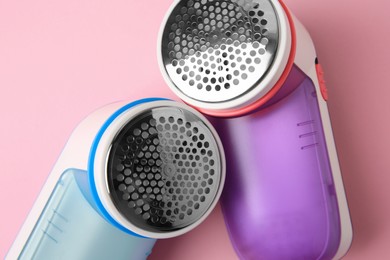 Photo of Modern fabric shavers on pink background, flat lay