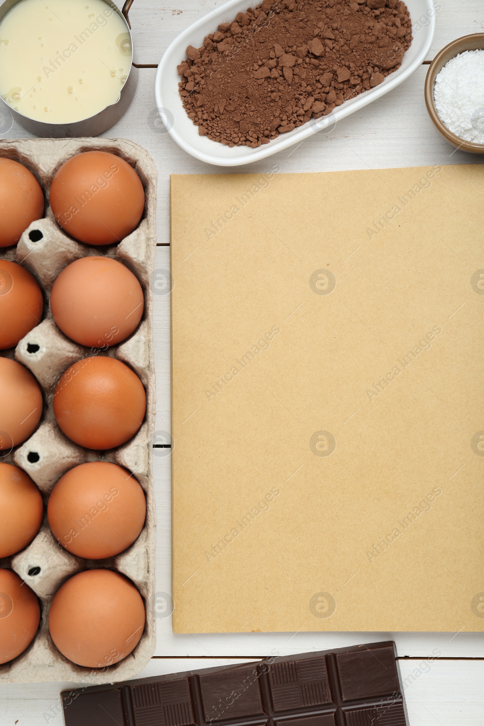 Photo of Blank recipe book and different ingredients on white wooden table, flat lay. Space for text