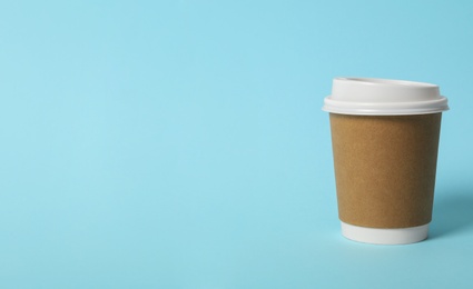 Takeaway paper coffee cup on light blue background. Space for text