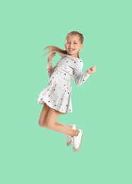 Image of Happy cute girl jumping on aquamarine background