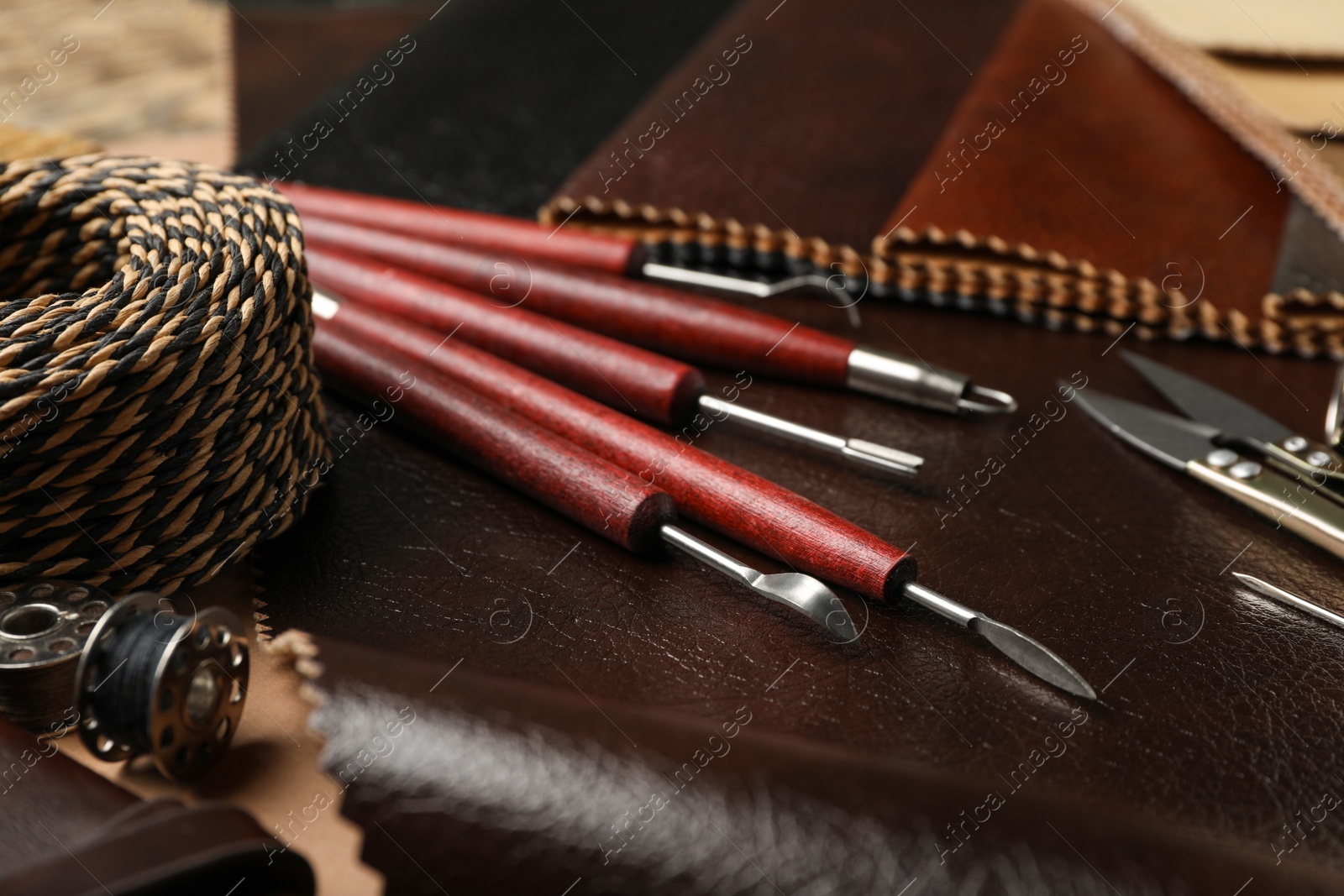 Photo of Leather samples and tools as background, closeup