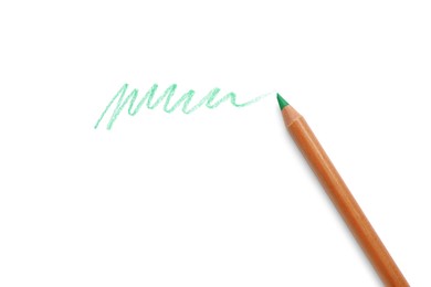 Photo of Green pastel pencil and scribble isolated on white, top view. Drawing supply
