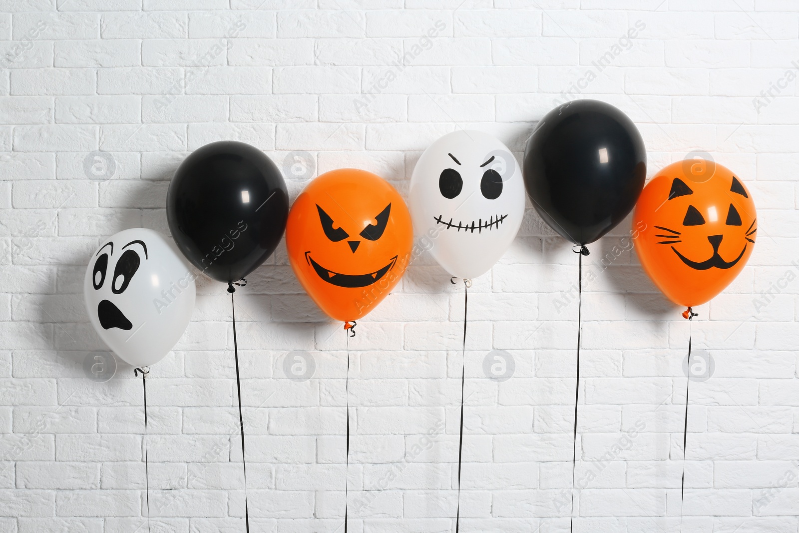 Photo of Color balloons for Halloween party against white brick wall