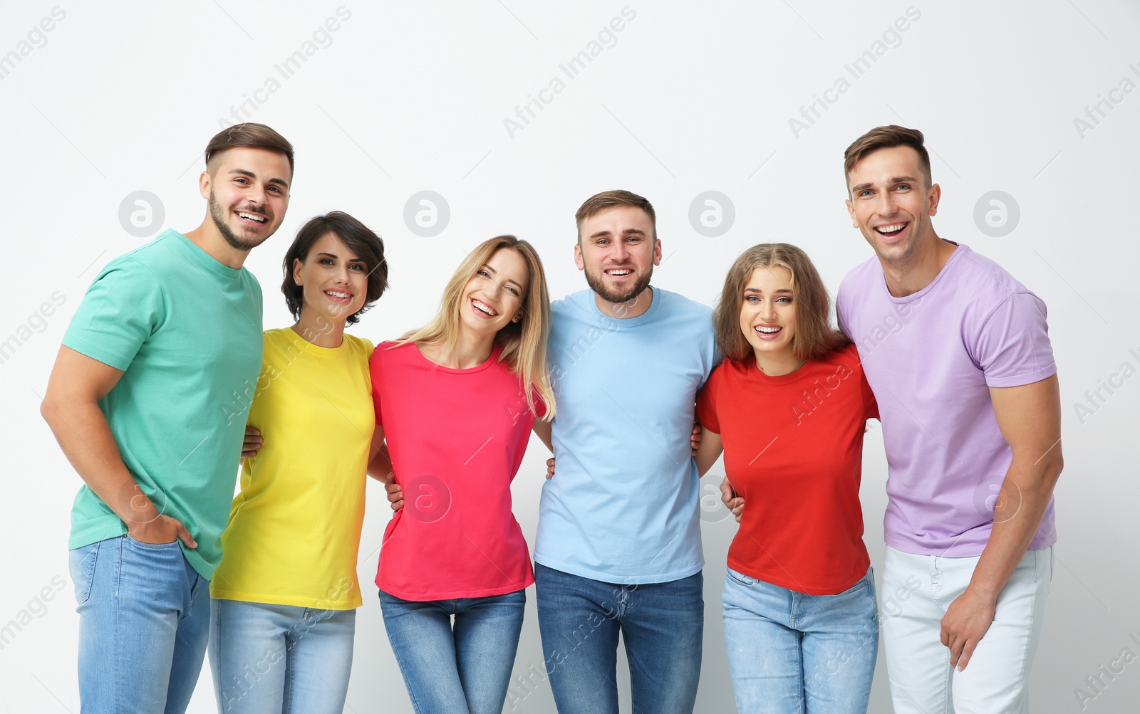 Photo of Group of young people hugging each other on light background. Unity concept