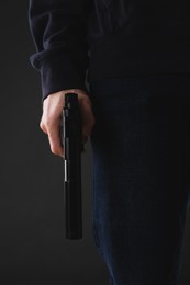 Photo of Man holding gun on black background, closeup