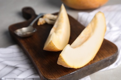 Wooden board with slices of ripe melon on table, closeup