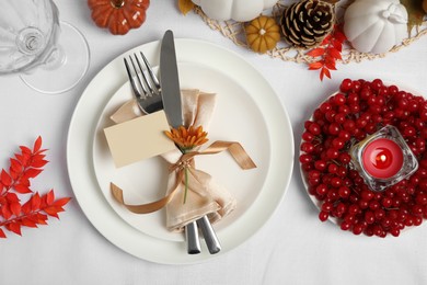 Beautiful autumn place setting with blank card and decor for festive dinner on table, flat lay