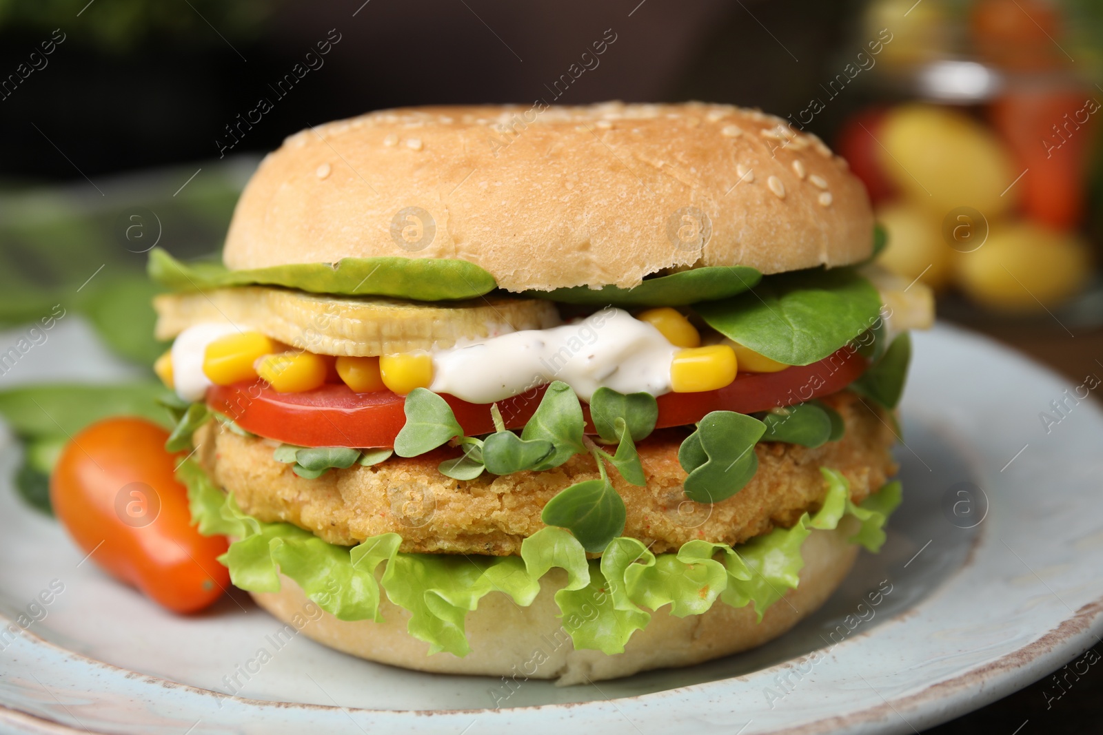 Photo of Tasty vegan burger with vegetables, patty and microgreens on white plate, closeup