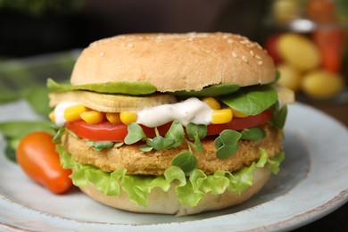 Photo of Tasty vegan burger with vegetables, patty and microgreens on white plate, closeup