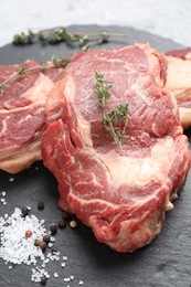 Photo of Fresh raw beef cut with spices on table, closeup