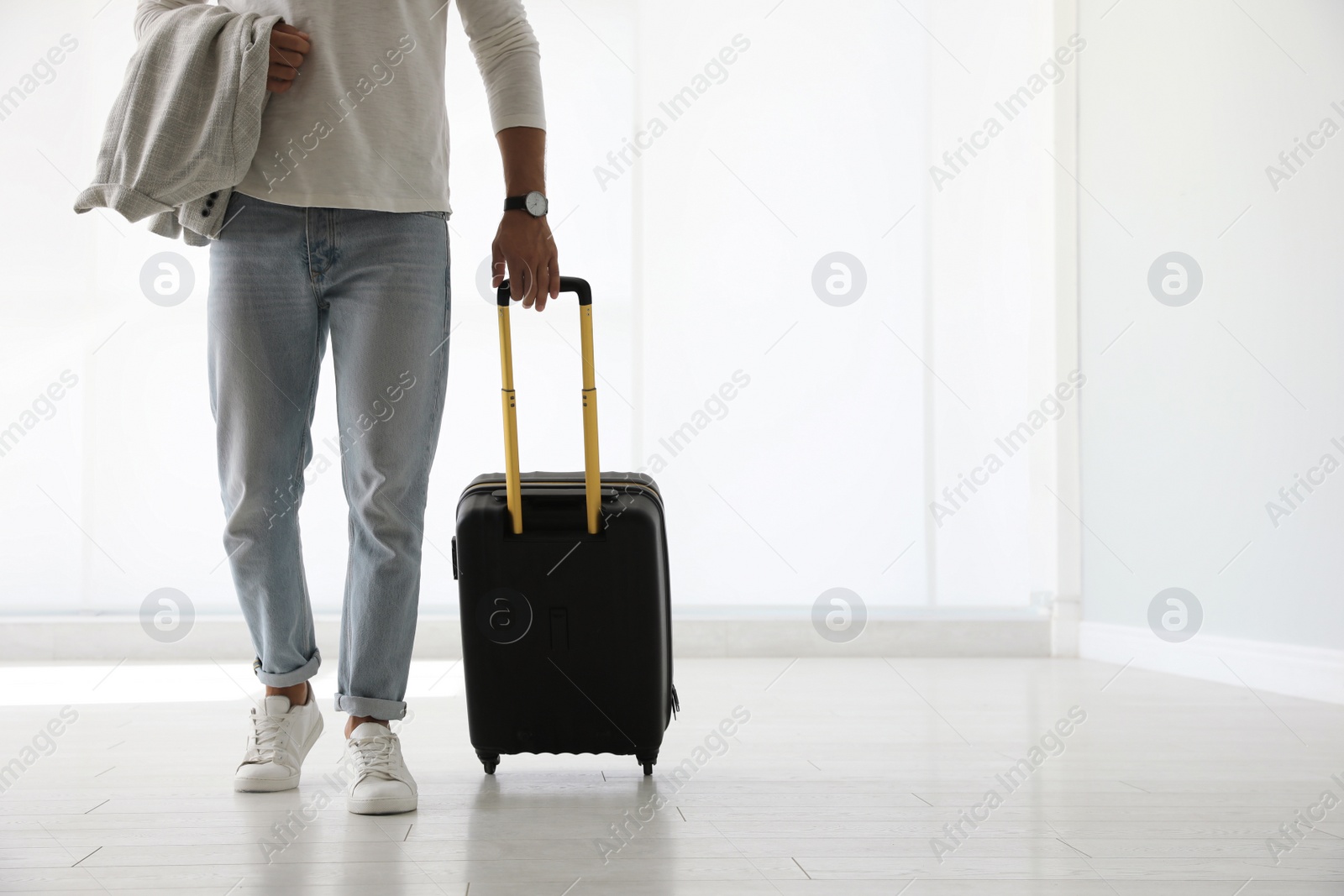 Photo of Man with black travel suitcase in airport. Space for text