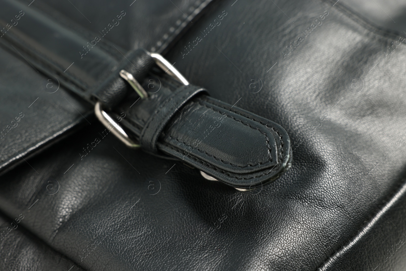 Photo of Black natural leather with buckle as background, closeup