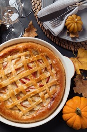 Photo of Delicious homemade apple pie and autumn decor on black table, flat lay. Thanksgiving Day celebration