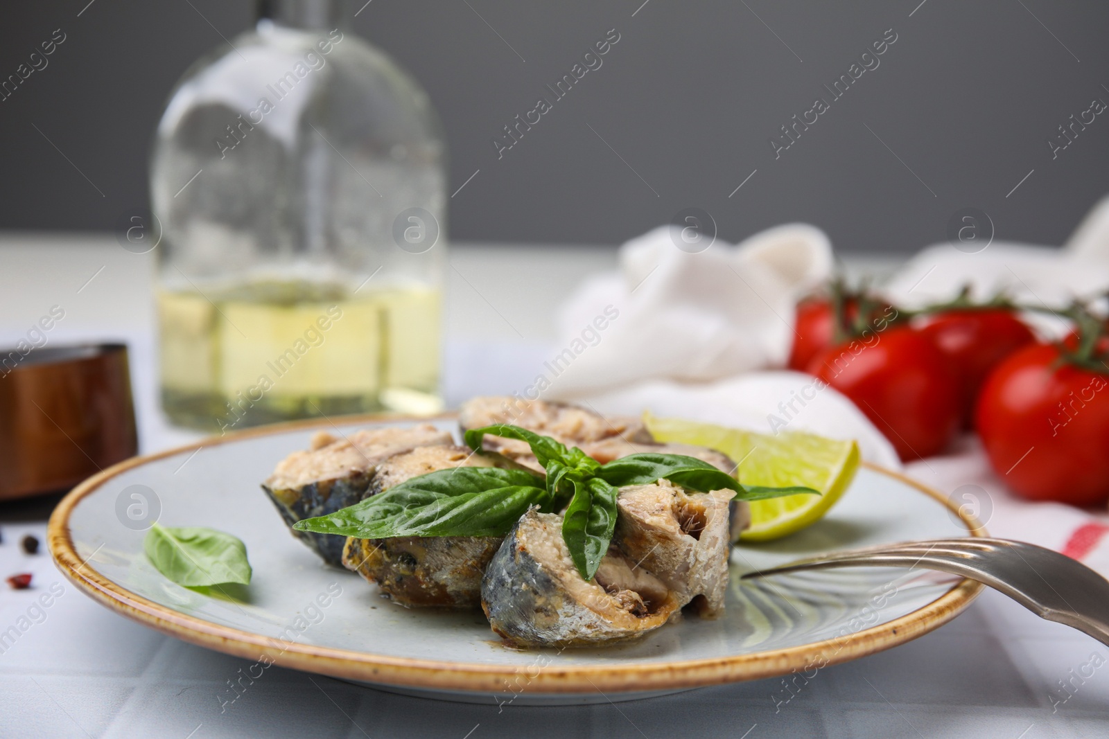 Photo of Canned mackerel chunks served on white tiled table, closeup