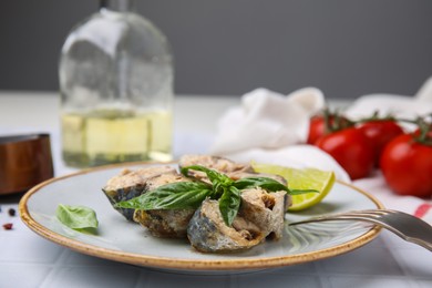 Canned mackerel chunks served on white tiled table, closeup