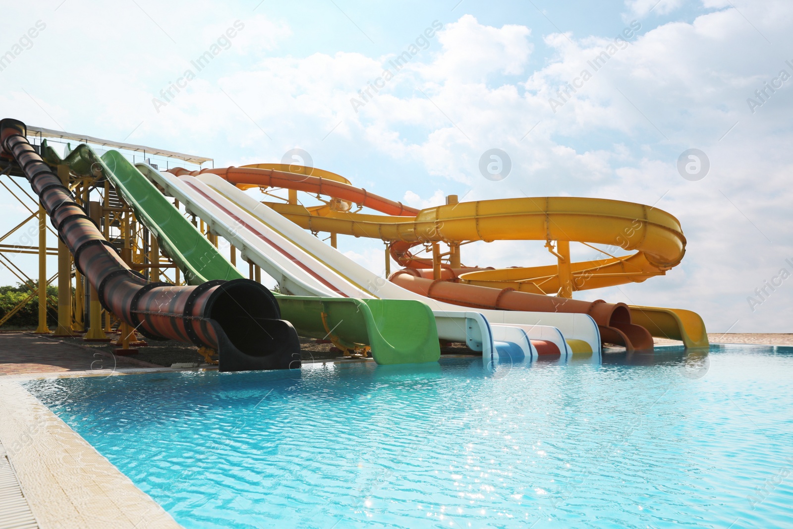 Photo of Beautiful view of water park with colorful slides and swimming pool on sunny day