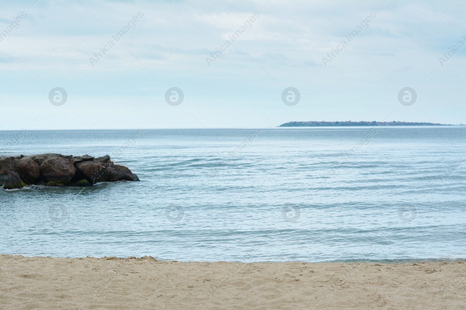 Photo of Beautiful view on sea with rock breakwater near sandy beach