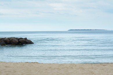 Photo of Beautiful view on sea with rock breakwater near sandy beach
