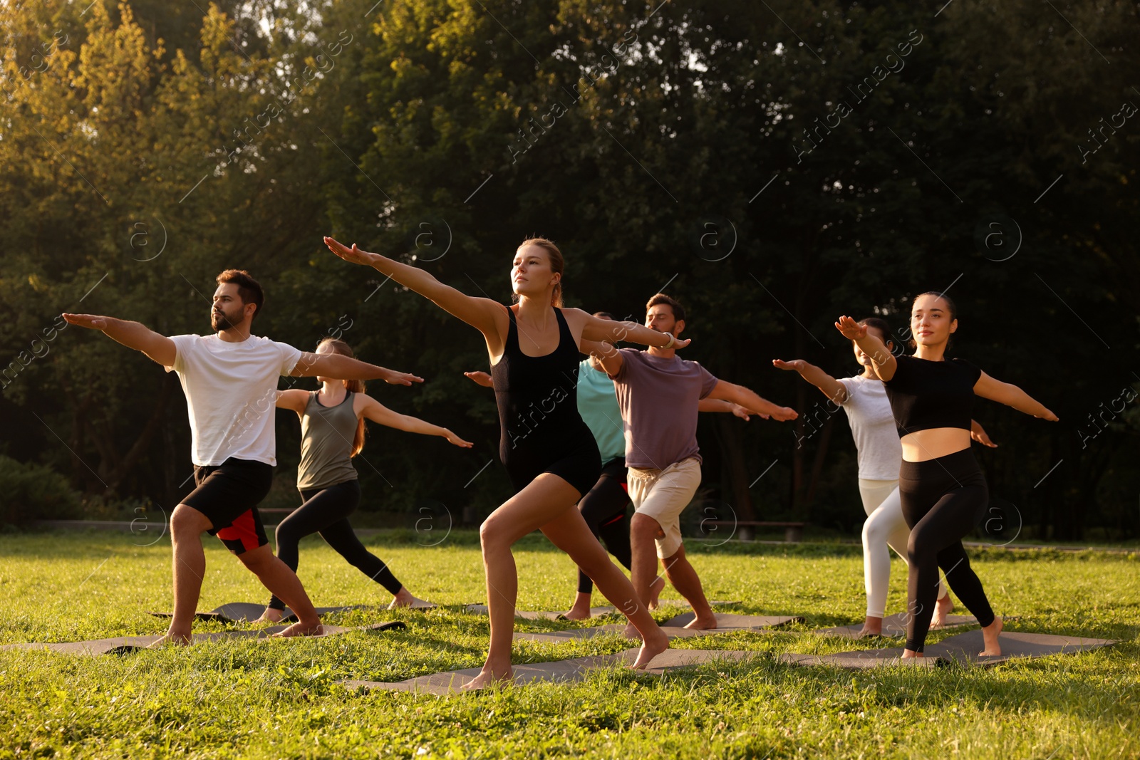 Photo of Group of people practicing yoga on mats outdoors