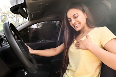 Photo of Young woman suffering from heart attack in car