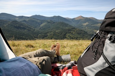 Photo of Tourist resting inside of camping tent in mountains, closeup
