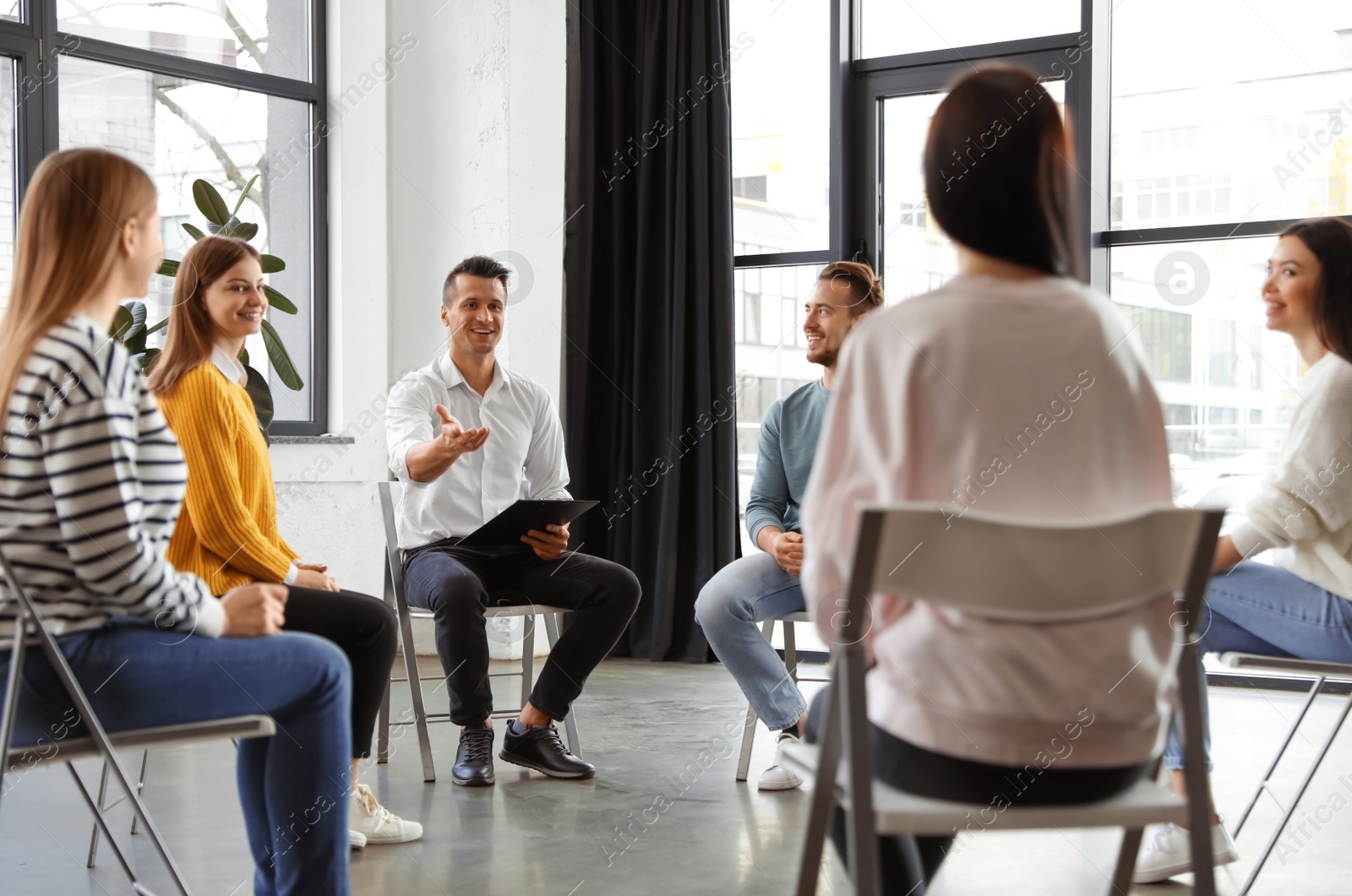 Photo of Psychotherapist working with patients in group therapy session indoors