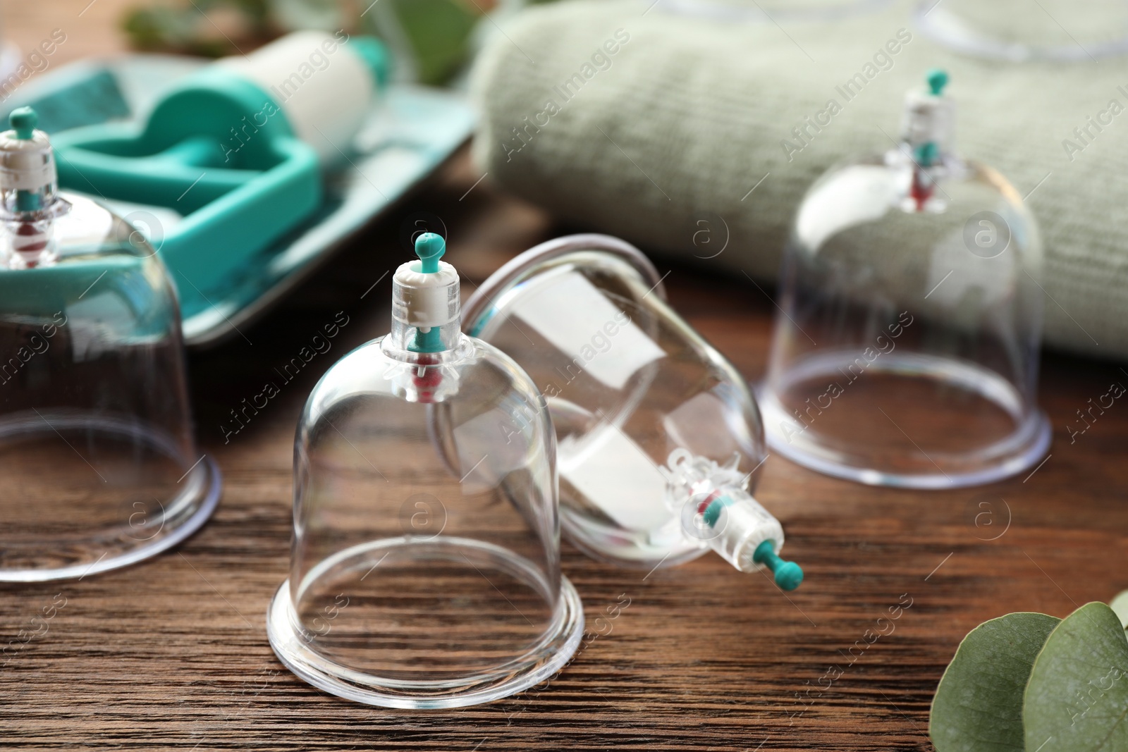 Photo of Cupping therapy. Plastic cups on wooden table, closeup