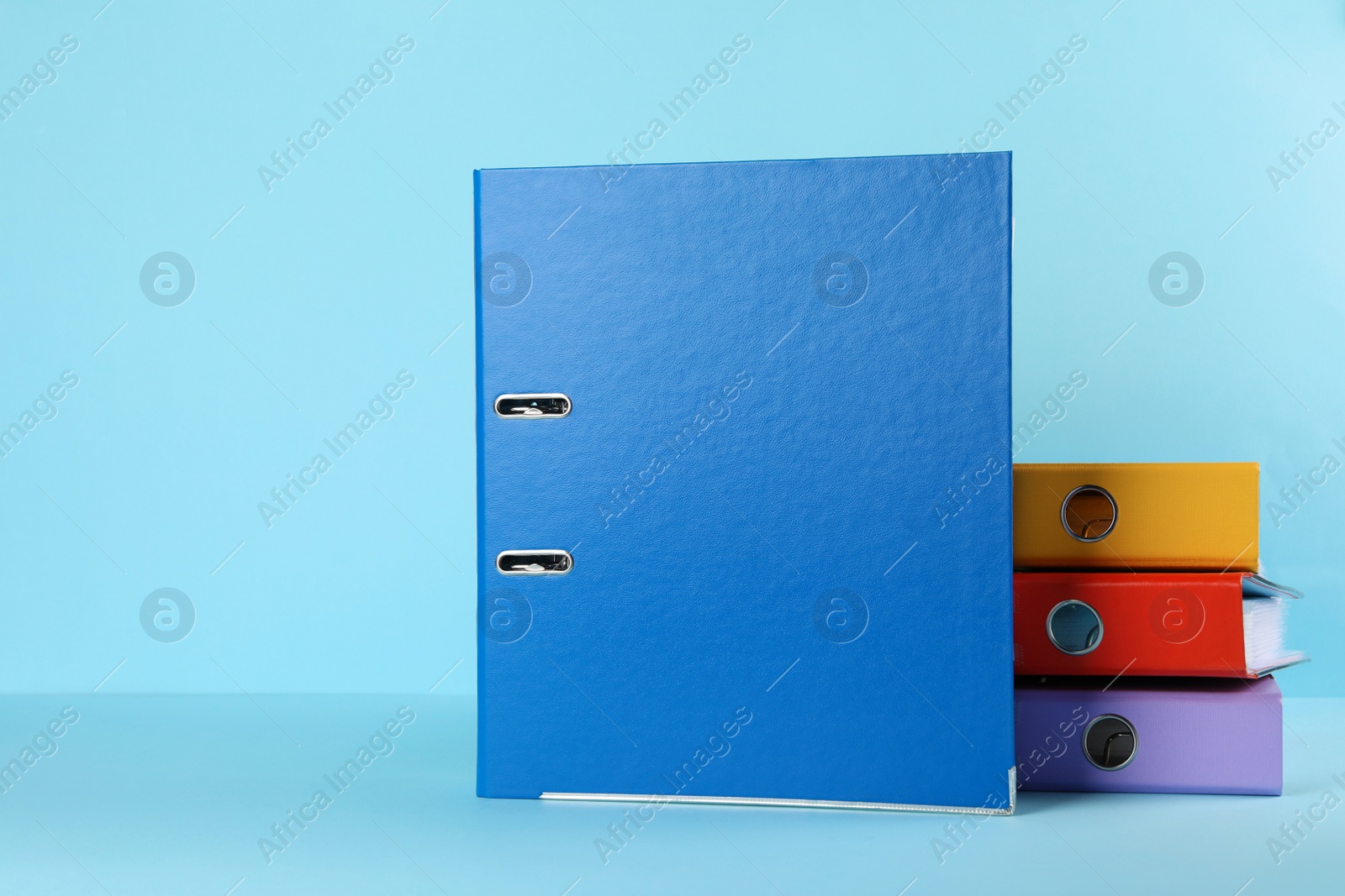 Photo of Hardcover office folders on light blue background