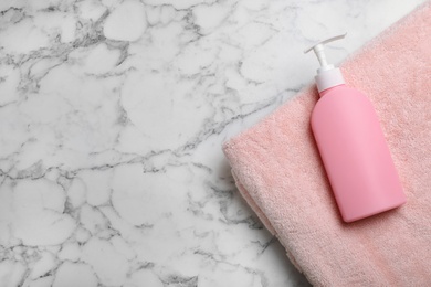 Photo of Towel and shampoo on marble background, top view with space for text