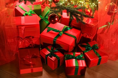 Photo of Beautifully wrapped gift boxes under Christmas tree indoors