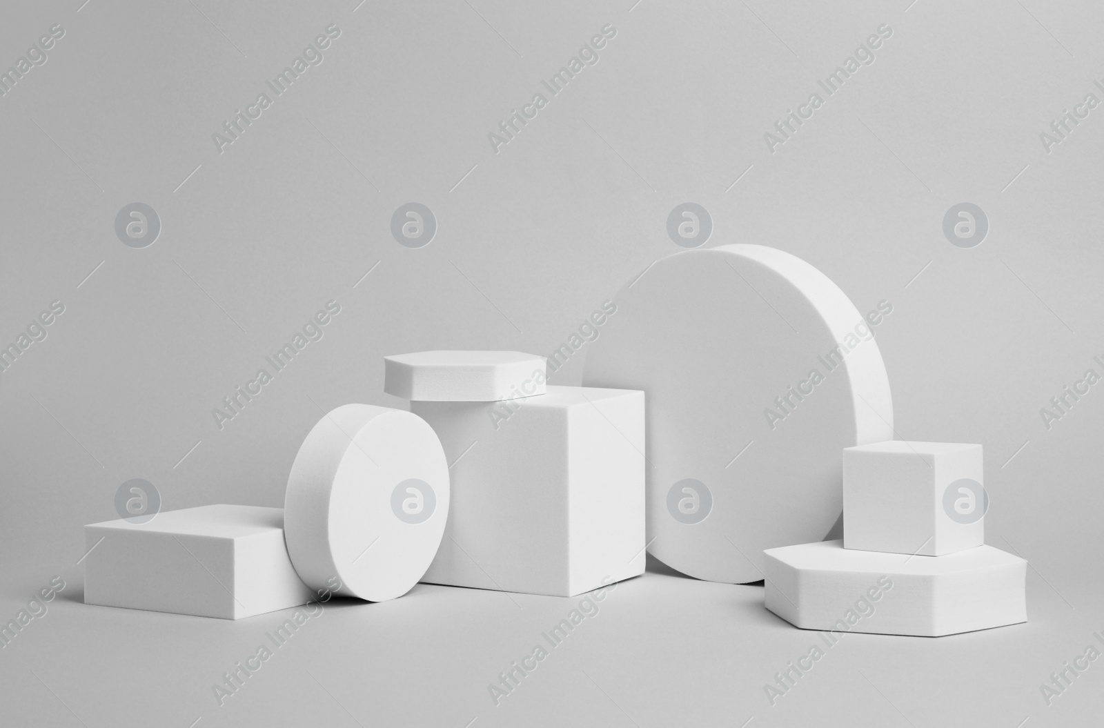 Photo of Scene for product presentation. Podiums of different geometric shapes on light grey background