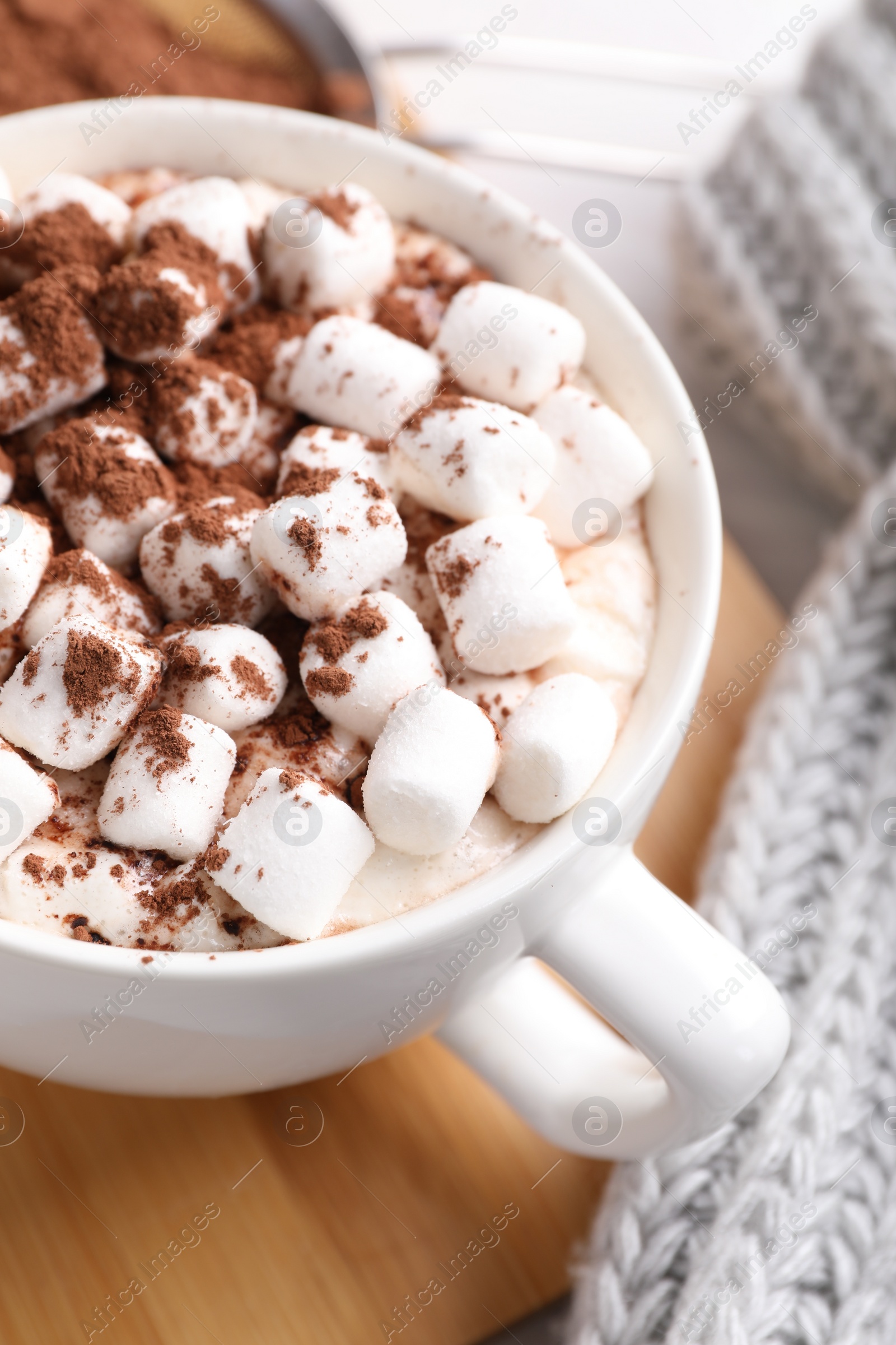 Photo of Cup of aromatic hot chocolate with marshmallows and cocoa powder on table, closeup