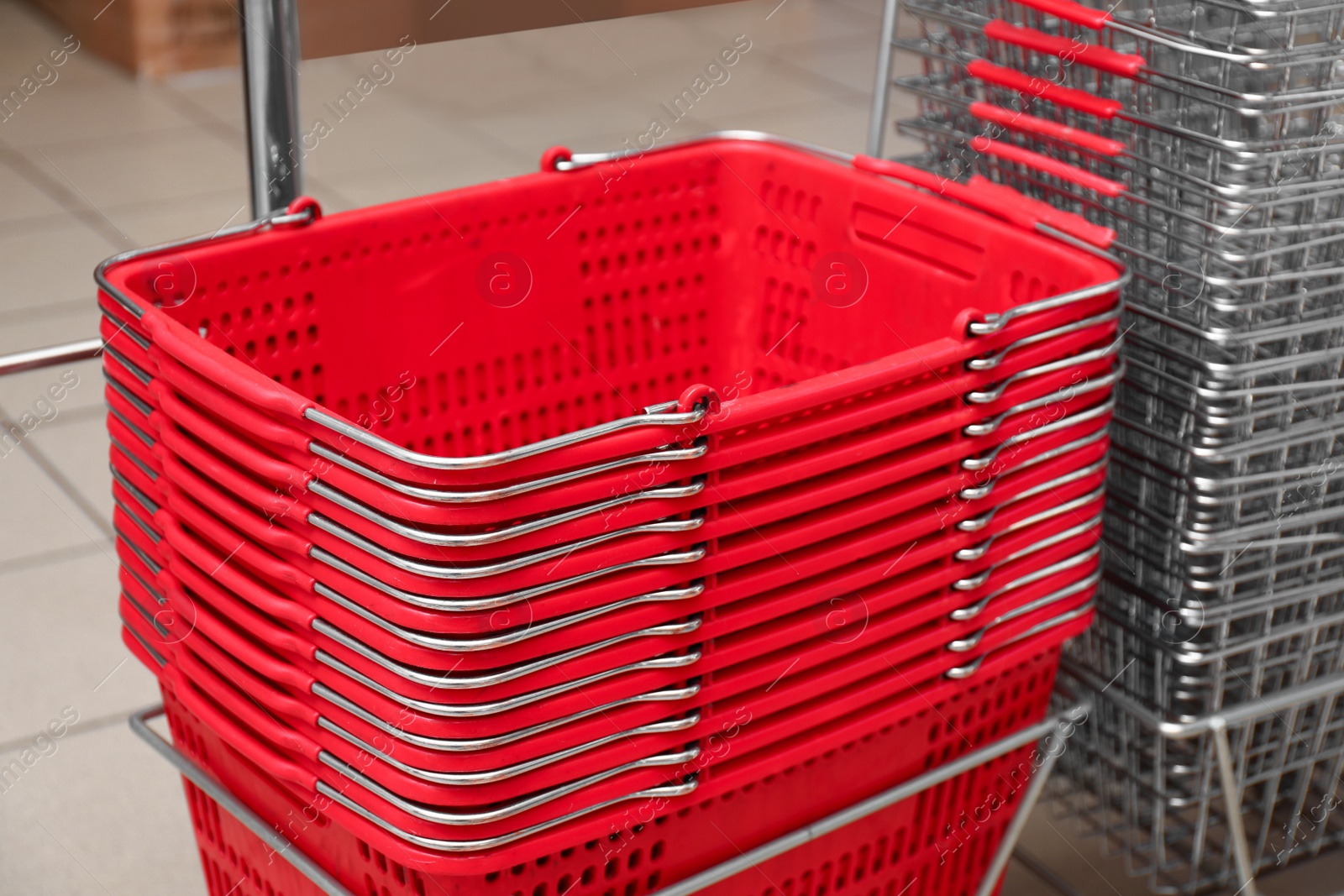 Photo of Stack of empty shopping baskets in supermarket, closeup