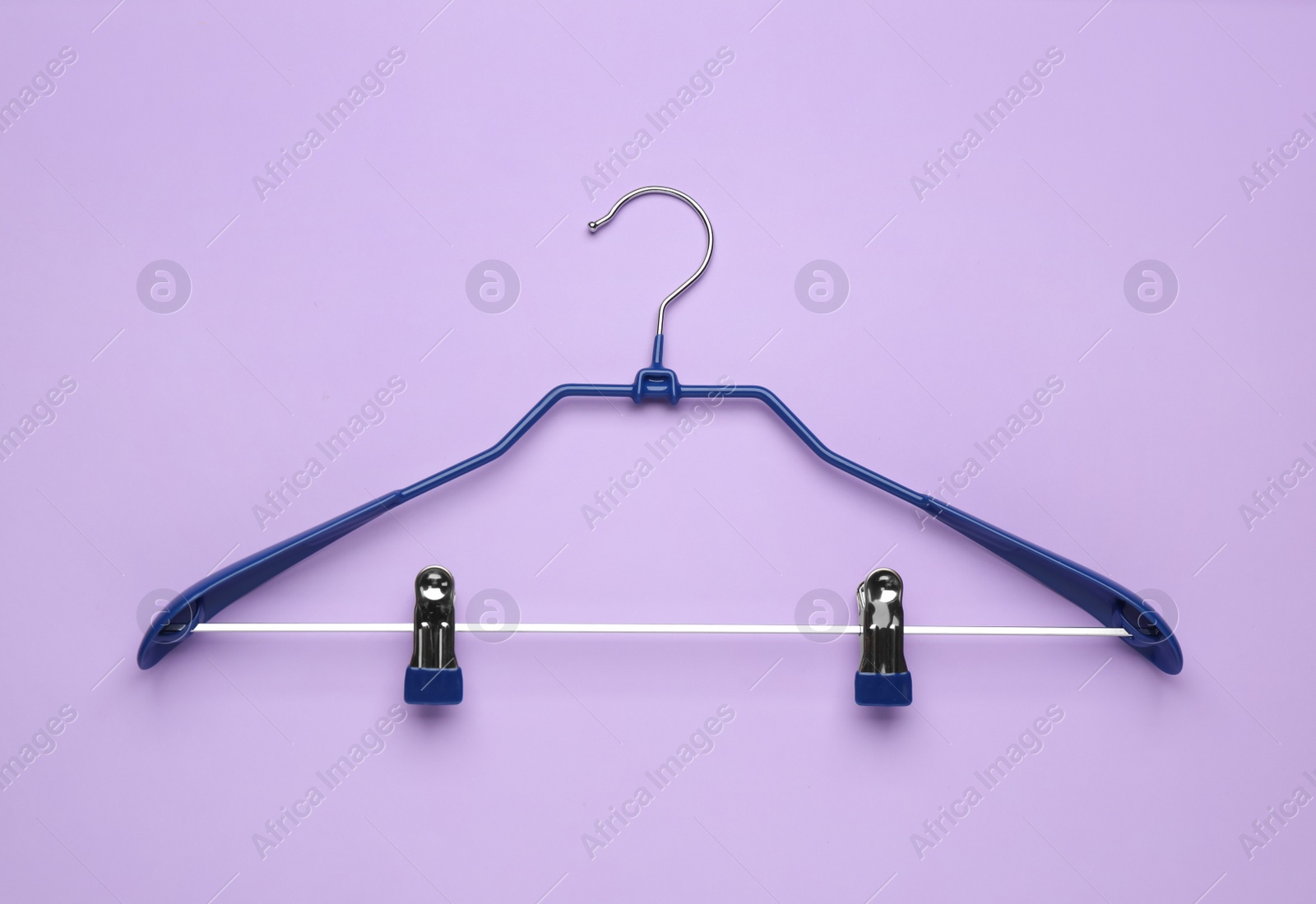 Photo of Empty hanger on lilac background, top view