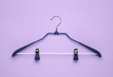 Photo of Empty hanger on lilac background, top view