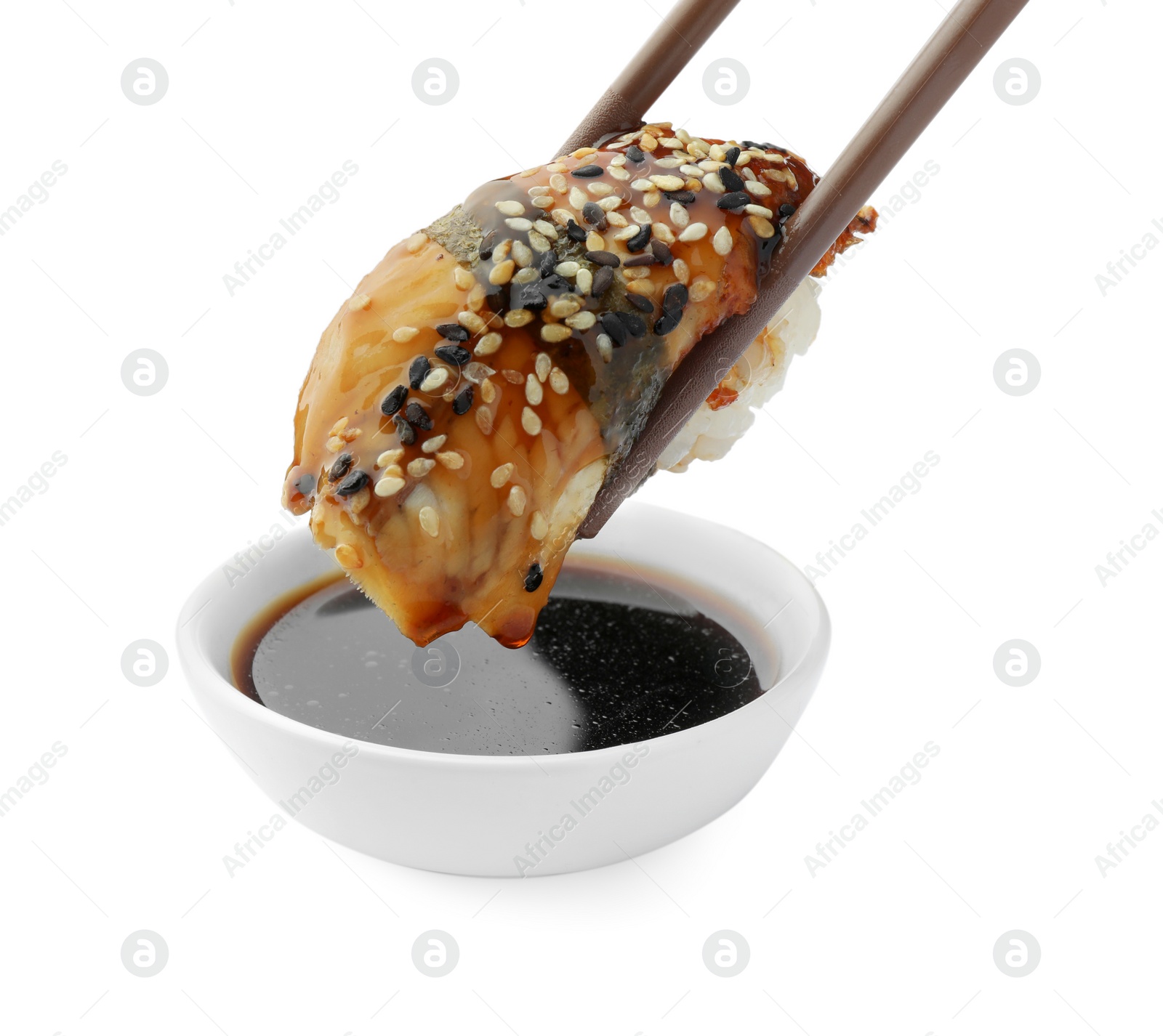 Photo of Dipping tasty sushi into soy sauce isolated on white