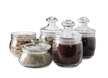 Photo of Brown and polished rice in jars isolated on white