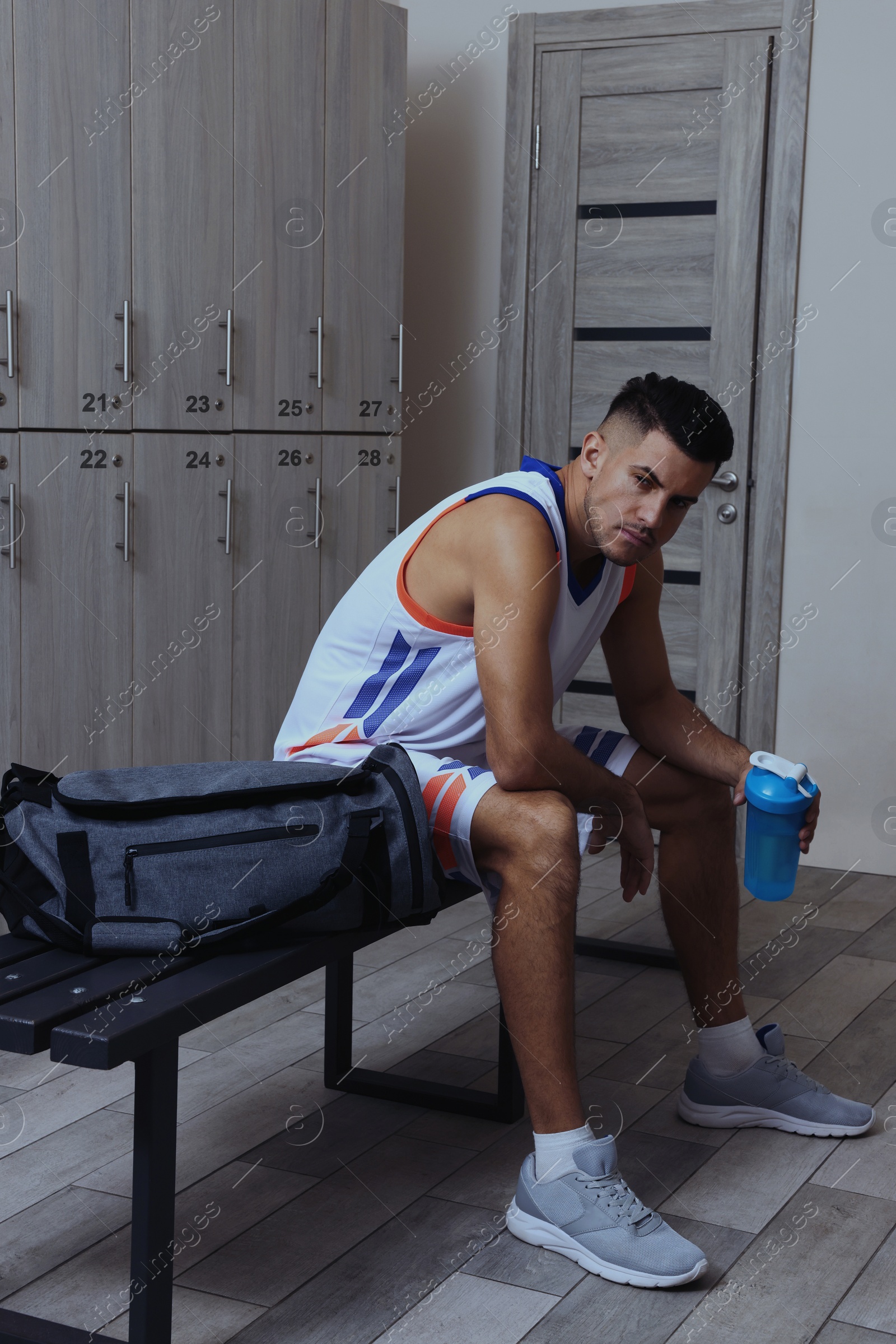 Image of Handsome man with shaker in locker room