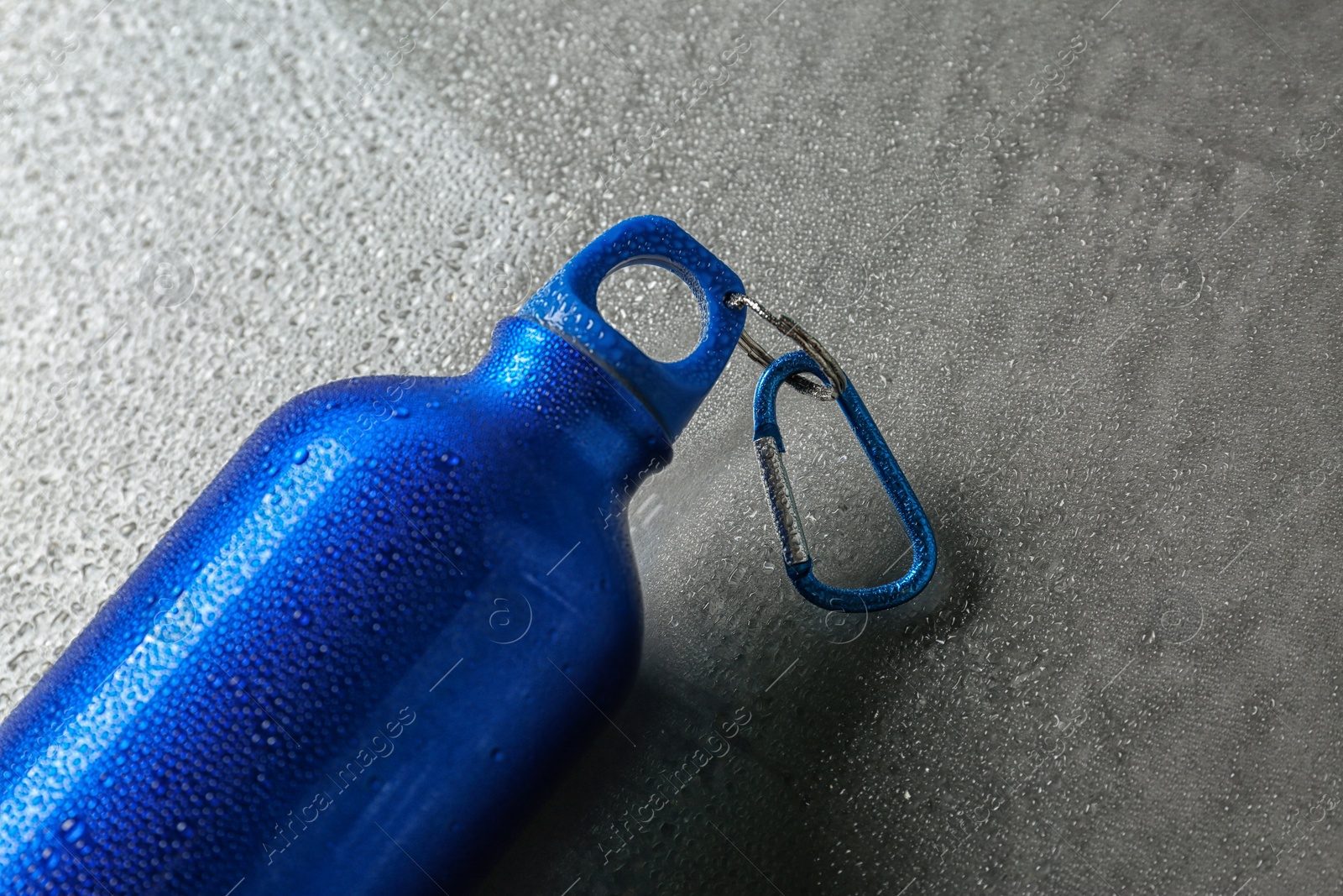 Photo of Aluminum sports water bottle on gray table. Space for text