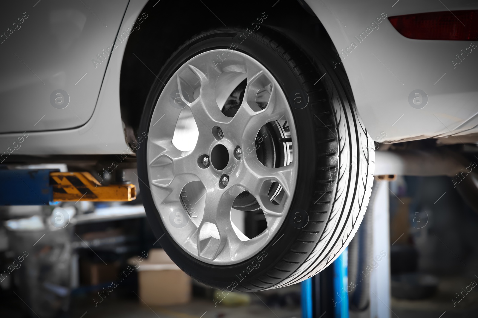 Photo of Car on lift at tire service, closeup